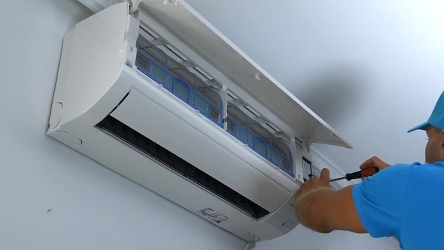 Professional repairman connects and repairs air conditioning