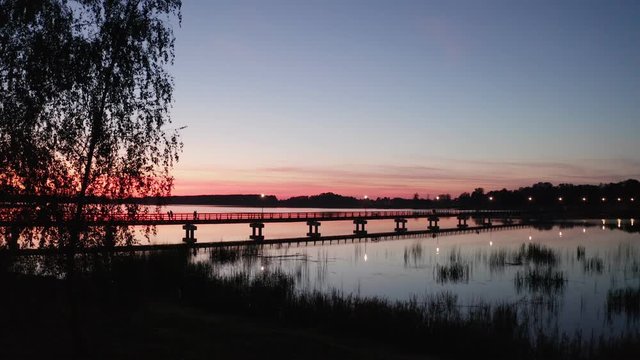 Drone Flight at Sunset by the lake Sirvena in Birzai - the longest wooden bridge in Lithuania.The bridge is located in Regional Park, connecting Birzai with Astravas Manor on the northern edge of the