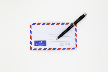 Airmail envelope and black pen on white background.