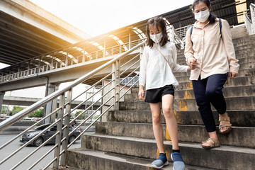 Daily routine of asian daughter child girl and mother suffer from inhalation of toxic fumes in the city everyday,people wearing face mask protection concept of air pollution,dust allergies