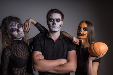 Girls and a guy with scary painted faces skeletons and ghosts to a Halloween party