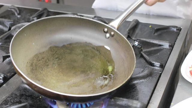 Cottura pesce spigola nella padella di un ristorante importante
