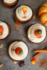 Homemade pumpkin Cupcakes with cream cheese frosting with halloween candy topping, selective focus