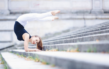 Beautiful gymnastic acrobat practicing outdoors