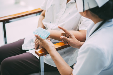 Caregiver giving blister pack to senior woman at home