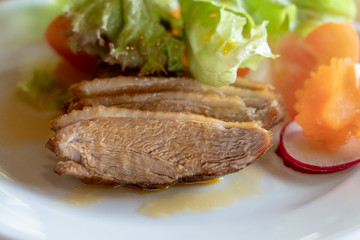 Duck breast sliced with passion fruit sauce and salad in restaurant.