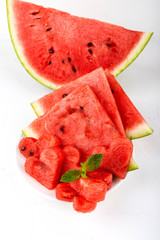 Sliced watermelon in the shape of hearts and ordinary slices on a white background. Close-up. Top view.