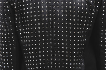 Back of a black leather jacket with metal rivets. Biker or punk studded style. Sample of stylish...