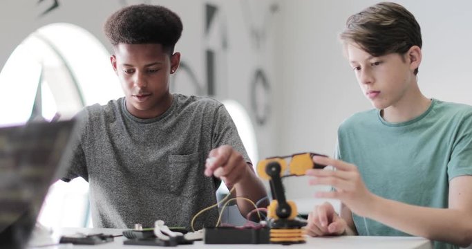 High School Students Working On A Robotic Arm In Class