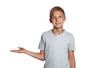 Close-up portrait of a blonde teenage boy in a white t-shirt posing isolated on white studio background. Concept of sincere emotions.