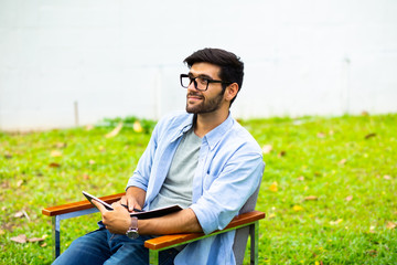 Obraz premium handsome young businessman relaxing and working on laptop computer on lawn at home