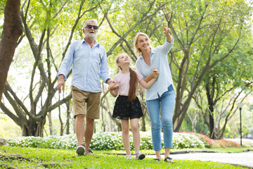 Obraz premium Happy male and female playing with children in park