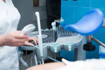 woman gynecologist doctor in white coat makes ultrasound scan to patient