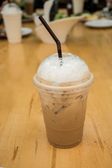 Ice coffee on wooden table in coffee shop or restaurant.