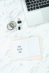 Vertical flat lay still life concept mockup. Workspace marble table with silver laptop and opened blank notebook with copy space