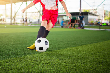 Blurry ball after boy soccer player speed run on green artificial turf to shoot it to goal. boy soccer player training. Asian   player in football academy.