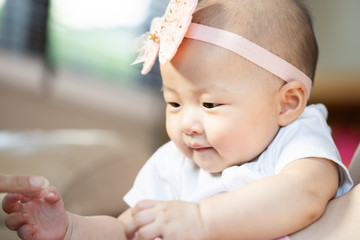 Asian baby happy in the room.Asian baby girl lying down on bed .Baby read book and play toy.