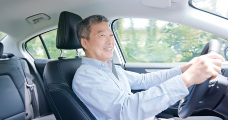 asian elderly man driving car