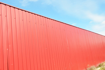 Close up on house red metal fence with blue sky and copy space