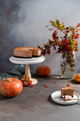 Chocolate raw cake in autumn composition with pumpkins, squashes and autumn leaves. Greeting card, recipe, cafe, confectionery, bakery, thanksgiving concept, copy space