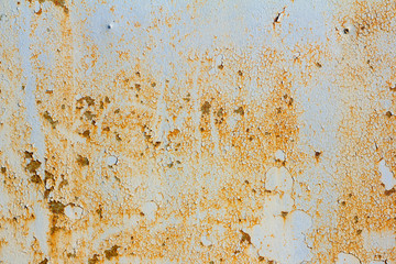 rusty metal wall with cracked blue paint, rust through the paint