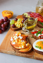 Fototapeta na wymiar Useful sandwiches stuffed with avocado, scrambled eggs, cottage cheese and fruit