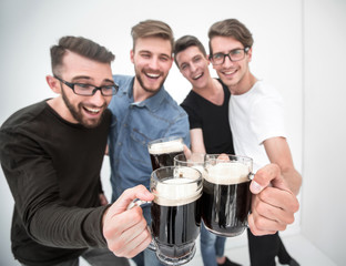 group of happy young men, clinking glasses of beer.