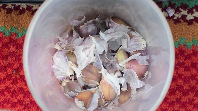 Top view of falling cloves of garlic in a jar for cooking