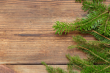 Naklejka premium Fur spruce pine coniferous branches on the brown brushed wooden background
