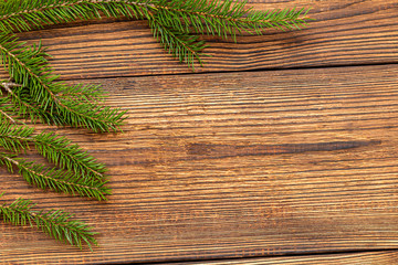 Fur spruce pine coniferous branches on the brown brushed wooden background