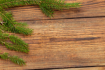 Naklejka premium Fur spruce pine coniferous branches on the brown brushed wooden background