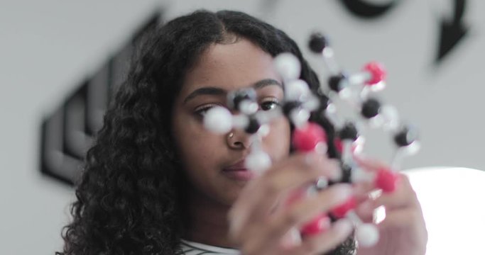 Closeup of african american student looking at molecular model