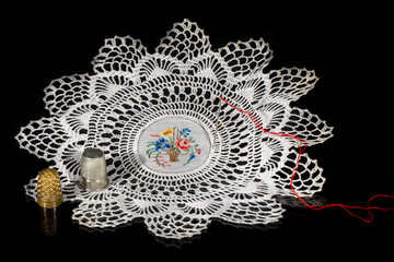 Gehäkeltes Deckchen mit Faden und Fingerhut