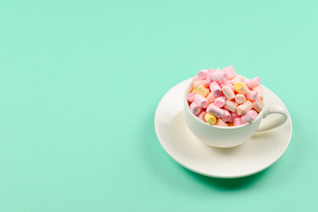 Fototapeta na wymiar Cup with marshmallow on a green background. Copy space.