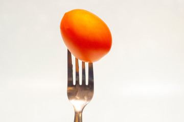 fresh tomato chorred on a table fork isolated on white background