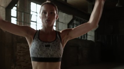 Fit woman doing jumping jack exercise at fitness gym
