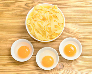 pasta on a wooden background next to a fresh egg on a wooden table. Minimalism. Dinner. Dinner. Fast food. homemade food