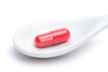 Isolated spoon with vitamin calcium on white background. Pharmacy, medicine concept. Taking medications and pills. Vitamins and minerals for health