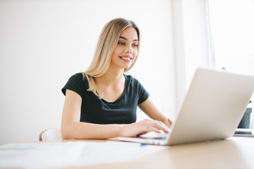 Fototapeta premium Pretty business freelancer woman working on her computer. Girl at her workspace. Start-up office background