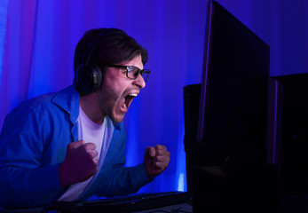 Gaming concept. Happy man in glasses celebrating victory in game © Prostock-studio
