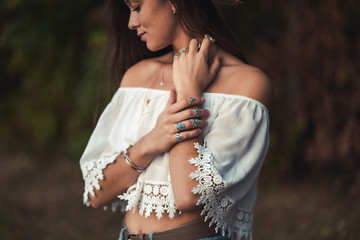 Fashionable boho chic woman in a white short blouse and with silver turquoise jewelry. Boho fashion. Stylish girl with silver rings using hippie style. © Goffkein