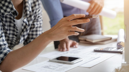 Engineer or architect teamwork working on construction project with building model and blueprint in office. Construction concept.