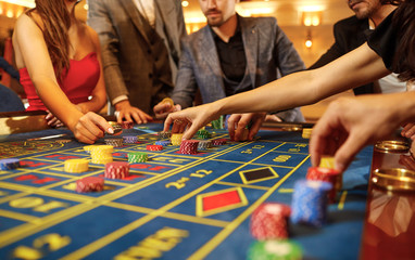 A group of people gamblers playing gambling poker roulette in a casino