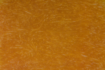 Yellow pumpkin cut in half with the texture of pulp. Pumpkin slices background closeup, top view