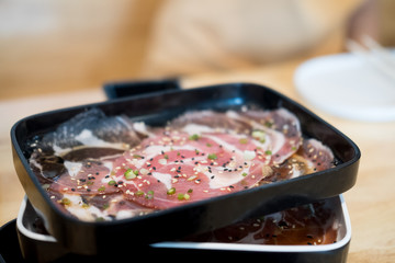 Raw beef being prepared on black tray , cooking meat