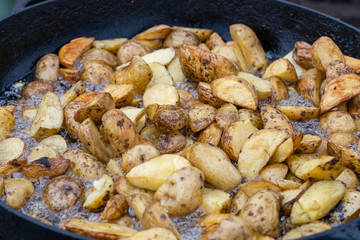 Roast potatoes in a large pan.Young potatoes are fried in oil, street food