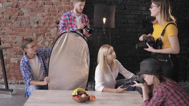 food photo, a group of people with digital cameras are trained on fashion shooting products in a professional studio