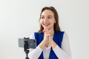 Blogging, broadcast and people concept - woman blogger is talking to the camera for her spectators