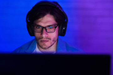 Young man in headset playing game at home