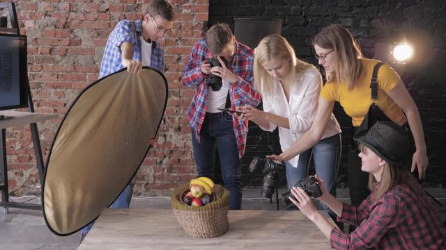 food photo, young creative cameramans with digital cameras and a phone take photos of fruits during a workshop on photography
